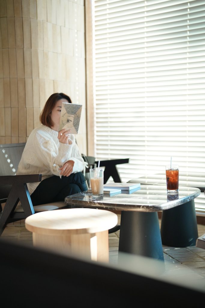 A woman reading the back cover of Elevator in Saigon by Thuận